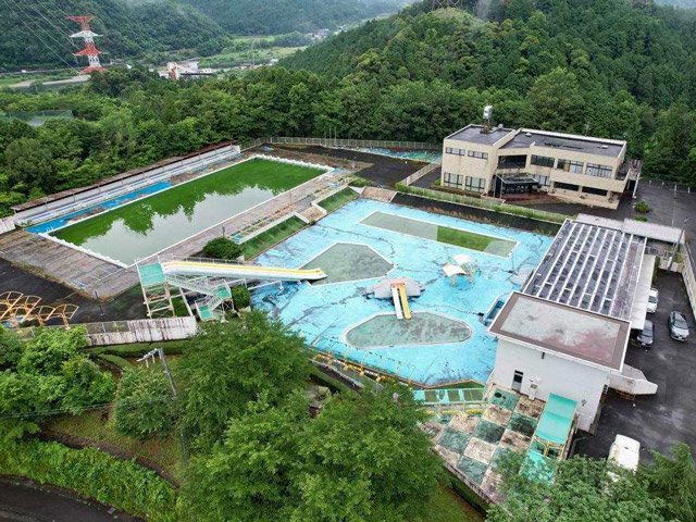 ドローンの博物館がオープン予定の旧勤労青少年ホーム（右奥）。左のプールも操作技術の研修で活用する予定＝美濃市曽代（ＲＯＢＯＺ提供）