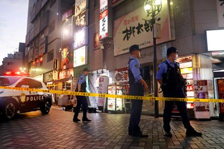 　男性が刺された現場ビル付近を警戒する警察官＝２５日午後７時５分ごろ、東京都豊島区西池袋