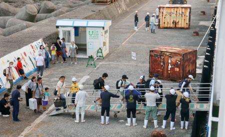 　鹿児島県十島村の小宝島から避難するため、フェリーに乗り込む住民ら＝６日午前５時４８分