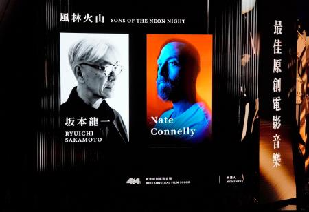 　金像奨の授賞式でモニターに映された坂本龍一さんの写真（左）＝１９日、香港（共同）