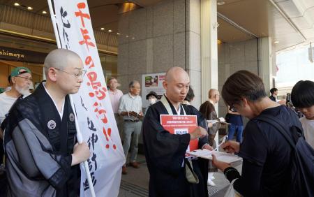 　北陸新幹線延伸の現行計画ルート見直しを求め、署名を呼びかける京都仏教会の僧侶ら＝２８日午後、京都市下京区