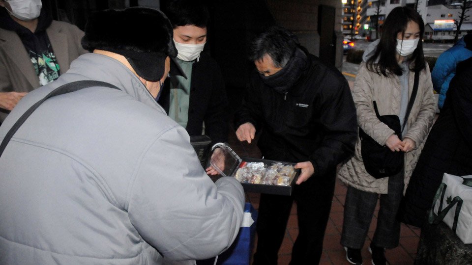 手作りの食事を受け取る人（左）＝３１日午後５時６分、岐阜市金町、金公園