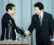 　小選挙区制導入を含む政治改革法案の修正合意を受け、握手する細川護熙首相（右）と河野洋平自民党総裁＝１９９４年１月、国会