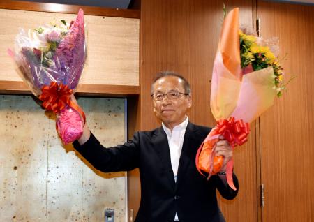 　千葉県船橋市長選で４選が確実となり、花束を手に笑顔の松戸徹氏＝２２日夜、千葉県船橋市