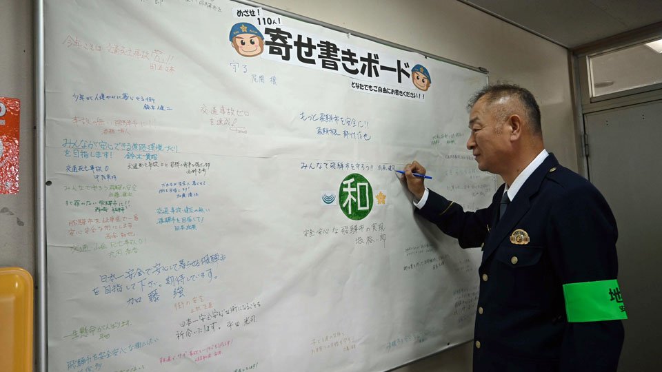「みんなで飛騨市を守ろう！！」と書き込んだ成原健司飛騨署長＝同署