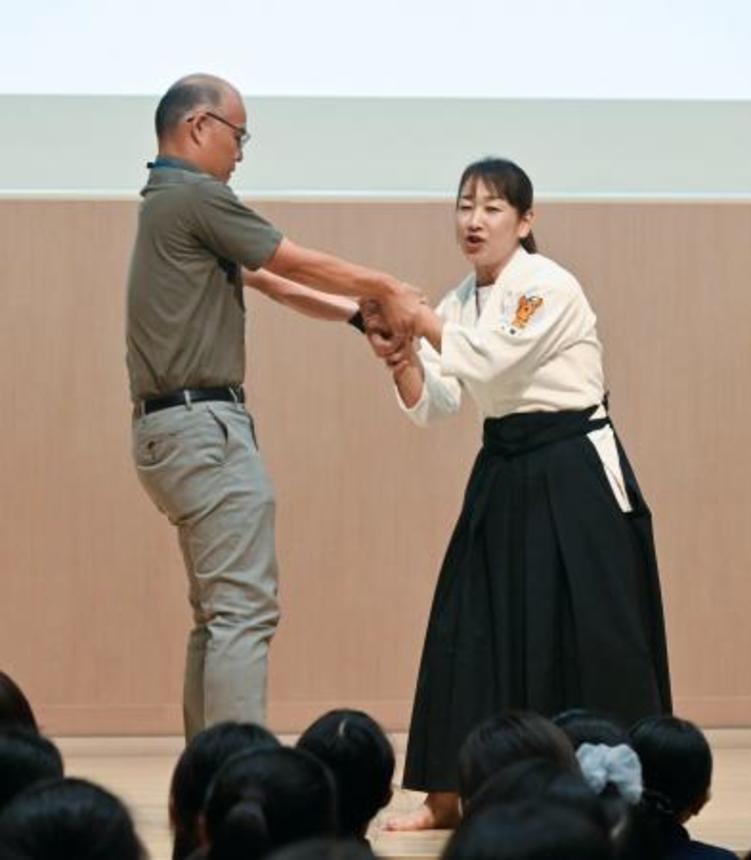　痴漢や盗撮の被害防止を目的とした防犯イベントで、護身術を実演する女性警察官（右）＝１５日午後、東京都品川区の品川女子学院