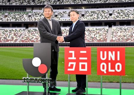 　パートナーシップ契約を締結し、記者会見で握手するＪリーグの野々村芳和チェアマン（左）とファーストリテイリングの柳井康治取締役＝２８日、東京・ＭＵＦＧスタジアム