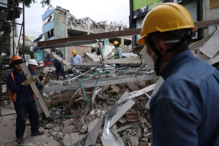 　１６日、コロンビア西部ペレイラで、地震によって倒壊した建物のがれきを片付ける人たち（ロイター＝共同）