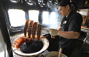 つぎ足しのタレにウナギをくぐらせる佐藤彰洋さん＝今月１０日、羽島市桑原町、魚勝