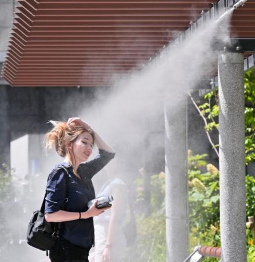 　全国的に気温が上昇した２８日、真夏のような暑さとなった東京・銀座でミストを浴び涼む女性