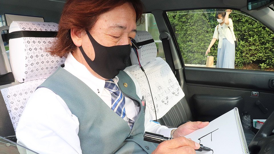 岸田文雄首相の政権運営について採点するタクシー運転手の男性＝１９日、瑞穂市別府、ＪＲ穂積駅前