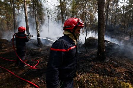 　パリ近郊フォンテーヌブロー付近の森で続く山火事の消火作業＝１４日（ロイター＝共同）