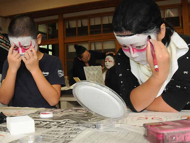 鏡を見ながら歌舞伎の化粧をする児童＝いずれも飛騨市河合町角川、河合小学校