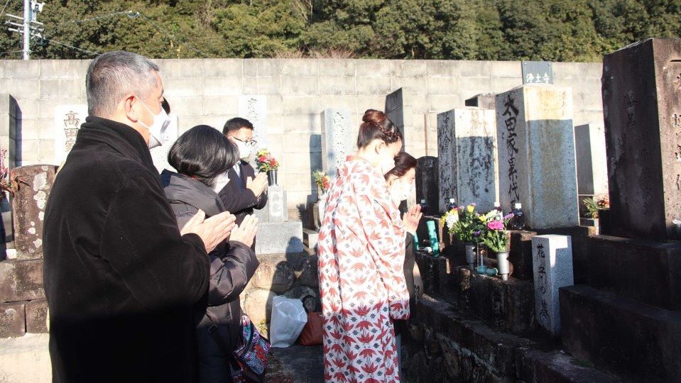 花子の墓に手を合わせる出演者ら＝岐阜市鴬谷町、浄土寺