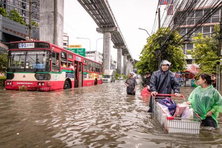 　降雨が続くタイ・バンコクで、冠水した道路を歩く人々＝２６日（ゲッティ＝共同）