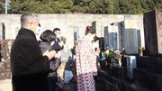花子の墓に手を合わせる出演者ら＝岐阜市鴬谷町、浄土寺