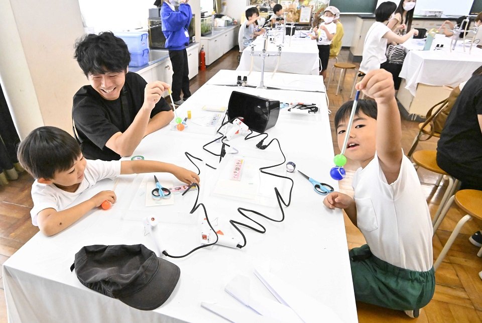 スーパーボールロケットを作る親子＝同