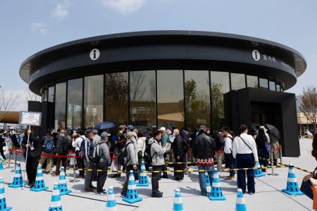 　有料の紙地図を求めて案内所に並ぶ人たち＝１６日、大阪市此花区の夢洲