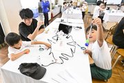 スーパーボールロケットを作る親子＝同