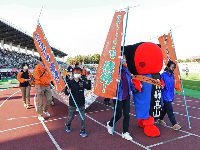 のぼり旗などを手に行進し、児童虐待の撲滅を呼び掛ける参加者＝岐阜市長良福光、長良川競技場