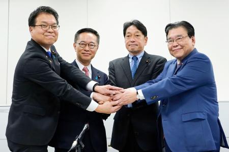 　「年収の壁」を１７８万円に引き上げることで合意し、握手する自民党の小野寺税調会長（中央右）と国民民主党の古川税調会長（同左）＝１８日午後、国会