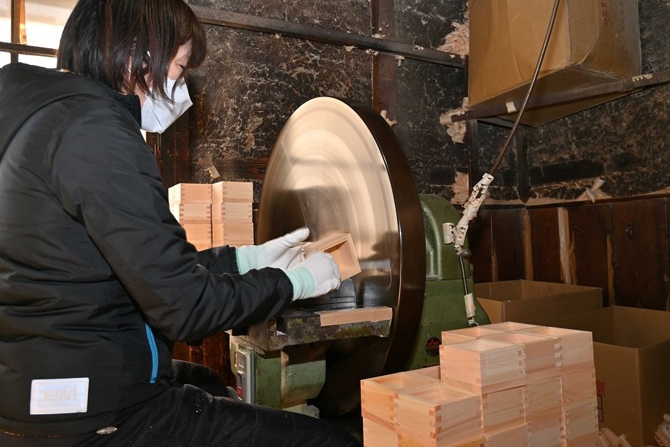 丸い円盤形のかんなで木升の表面をきれいに仕上げる職人＝大垣市西外側町、大橋量器