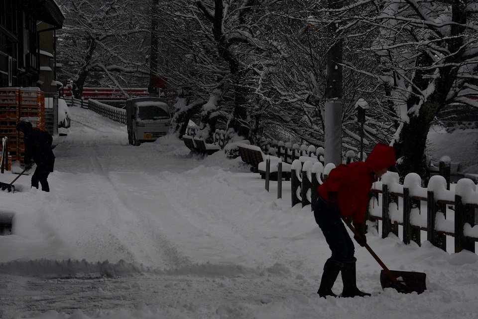 雪かきに追われる住民＝２５日午前７時３０分、高山市片原町