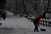 雪かきに追われる住民＝２５日午前７時３０分、高山市片原町