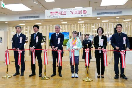 　「２０２５年報道写真展」のオープニングセレモニーで、テープカットする体操女子の杉原愛子選手（中央右）＝１０日午前、東京都中央区の日本橋三越本店