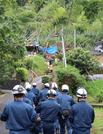 　大雨で土砂が流入し倒壊した住宅（奥）に向かう警察官ら＝１０日午前、鹿児島県姶良市