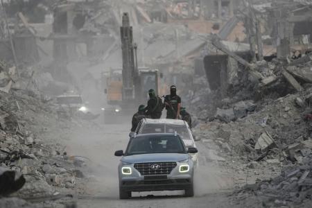 　ガザ北部ガザ市で人質の遺体を探すイスラム組織ハマスの戦闘員ら＝５日（ＡＰ＝共同）