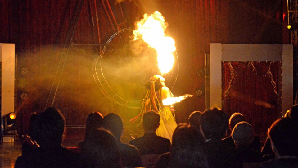 火を吹くパフォーマンスで観衆を沸かせる団員＝大垣市外野、イオンモール大垣北側駐車場特設会場