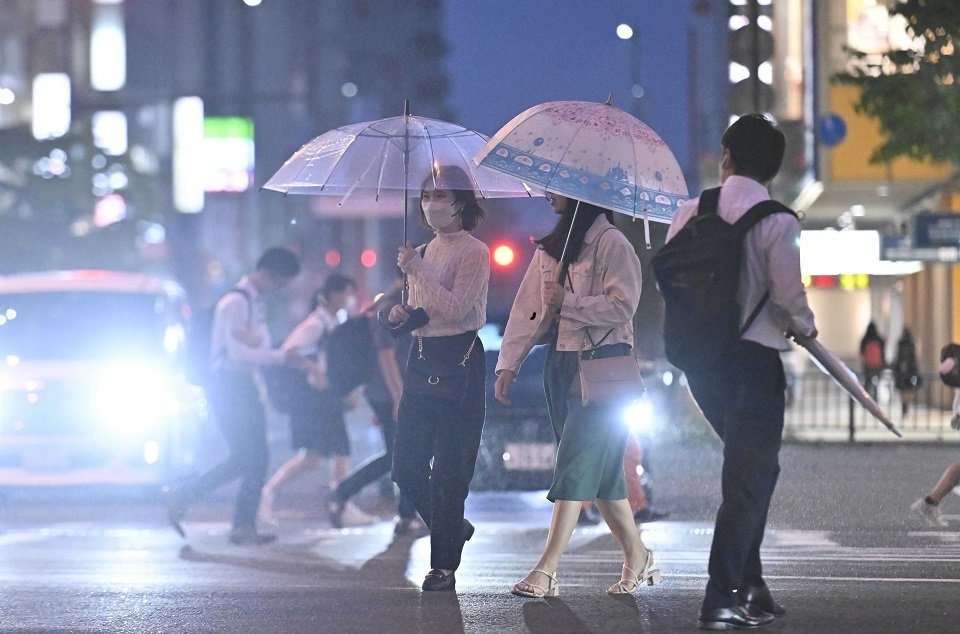 台風２号接近に伴う雨の中、傘を差して歩く人たち＝１日午後７時６分、岐阜市神田町
