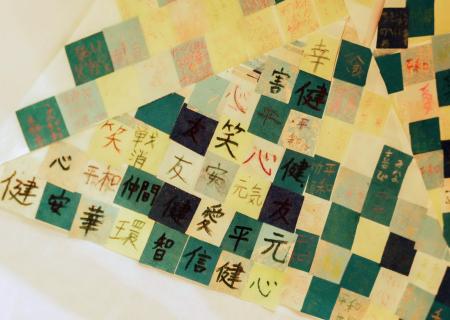 　オブジェの台座に貼られた「笑」などと書かれた和紙片＝２７日午前、和歌山県かつらぎ町