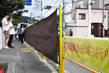 　コンビニ越しの富士山を撮影できるスポットに１年ぶりに設置された幕＝１４日午後、山梨県富士河口湖町