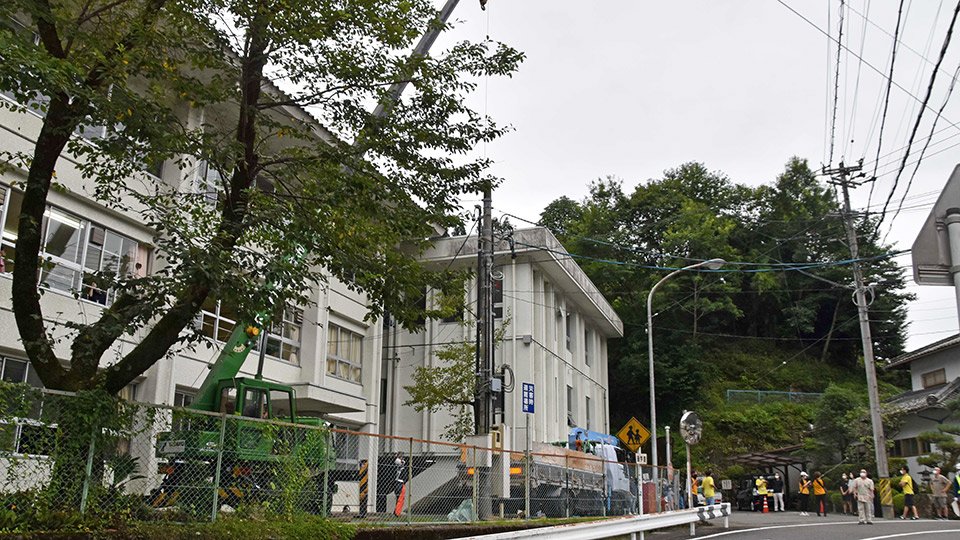 地域住民ら関係者に見守られながら伐採される桜の木＝下呂市焼石、中原小学校