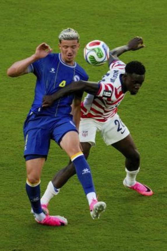 　サッカーＷ杯決勝トーナメント１回戦のボスニア・ヘルツェゴビナ戦で、相手選手を倒す米国のバログン（右）。レッドカードを受け、退場処分となった＝１日、サンフランシスコ（ＡＰ＝共同）