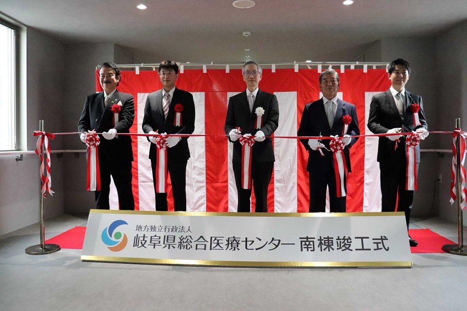 竣工式でテープカットする桑原尚志理事長兼院長（中央）ら＝同
