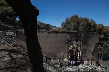 　フランス・マルセイユ郊外で、山火事により焼け落ちた家屋のそばに立つ消防隊員＝９日（ロイター＝共同）
