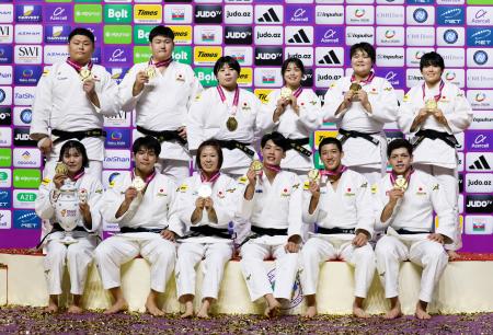 　柔道の世界選手権混合団体で８度目の優勝を果たし、金メダルを手に笑顔の（前列左から）田中志歩、田嶋剛希、玉置桃、内村秀資、田中龍雅、村尾三四郎、（後列左から）中野寛太、中村雄太、素根輝、大森朱莉、新井万央、前田凜＝１１日、アゼルバイジャン・バクー（共同）