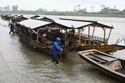 台風接近に伴う大雨により冠水した乗船場で鵜飼観覧船を係留する関係者＝２６日午後４時６分、岐阜市湊町