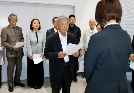 　山口県上関町役場で、担当職員（手前）に申し入れ書を提出する議連幹事長の小中進田布施町議（中央）ら＝２９日午後