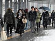 雪が降る中を出勤する人たち＝５日午前７時３８分、岐阜市神田町