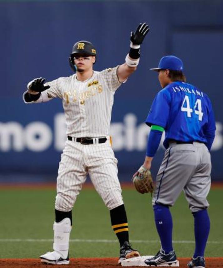 　１回、先制二塁打を放ちポーズをとる阪神・佐藤（左）＝京セラドーム