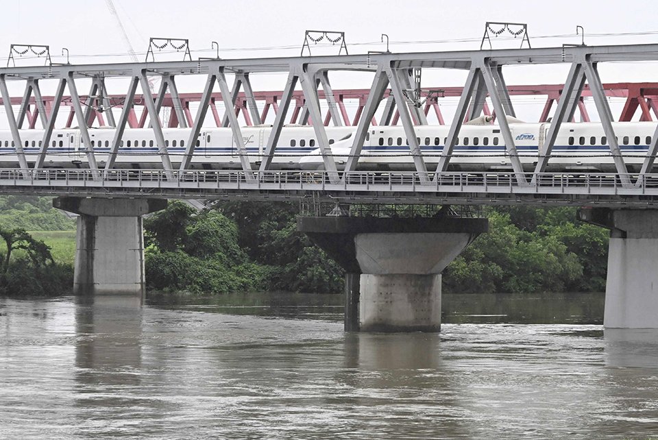 台風７、８号接近に伴う大雨で増水した川を渡る東海道新幹線＝２７日午前８時２６分、羽島市内、長良川（撮影・堀尚人）