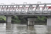 台風７、８号接近に伴う大雨で増水した川を渡る東海道新幹線＝２７日午前８時２６分、羽島市内、長良川（撮影・堀尚人）