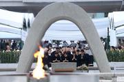 　米軍の原爆投下から８０年の「原爆の日」となり、慰霊碑に手を合わせる人たち＝６日午前５時３６分、広島市中区の平和記念公園