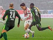 　ウォルフスブルク戦で競り合うフライブルクの鈴木（中央）＝ウォルフスブルク（共同）