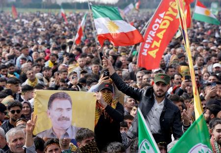 　トルコのクルド労働者党（ＰＫＫ）の指導者オジャラン受刑者が描かれた旗を持つ人＝３月２３日、イスタンブール（ロイター＝共同）