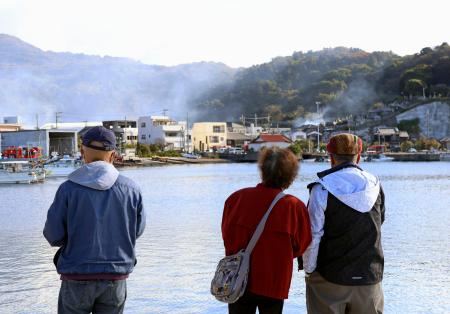 　大分市佐賀関の大規模火災現場を見つめる人たち＝１９日午前９時４１分